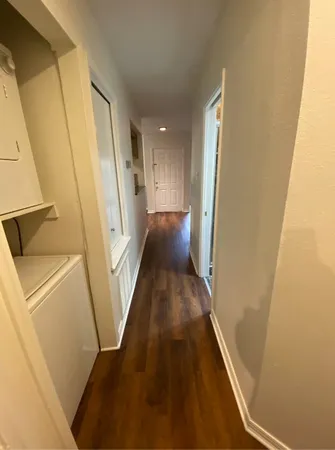 a view of a hallway with wooden floor and staircase