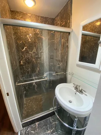 a bathroom with a sink mirror and a shower