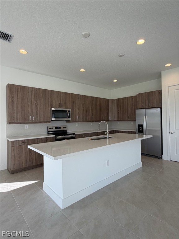 5166 Julienne Road Immokalee, FL 34142 - Photo 8 of 29 a large kitchen with stainless steel appliances a large counter top a stove a sink dishwasher and a refrigerator with wooden floor