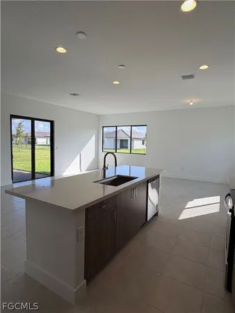 a kitchen with kitchen island a sink dishwasher a stove and a refrigerator with wooden floor