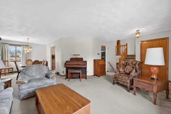 a dining room with furniture a chandelier and wooden floor
