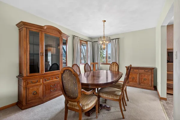 a kitchen with stainless steel appliances granite countertop a stove a sink dishwasher a dining table and chairs with wooden floor
