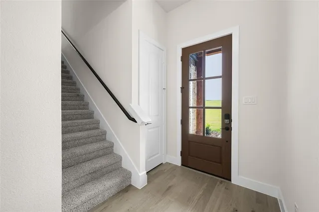 a view of an entryway with wooden floor and door