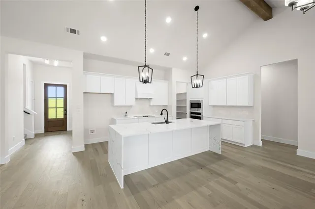 a large kitchen with white cabinets and stainless steel appliances