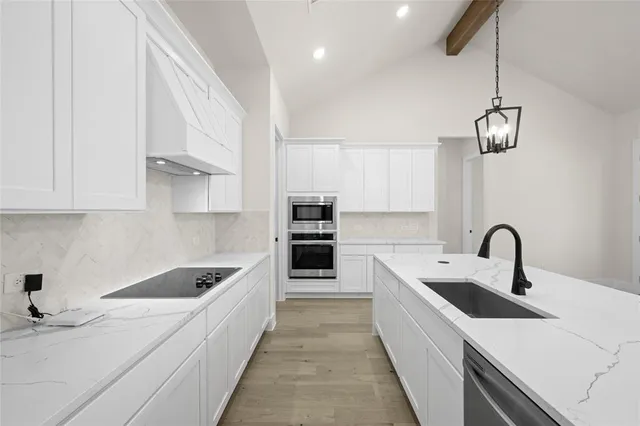 a kitchen with stainless steel appliances kitchen island a white counter space a sink and cabinets