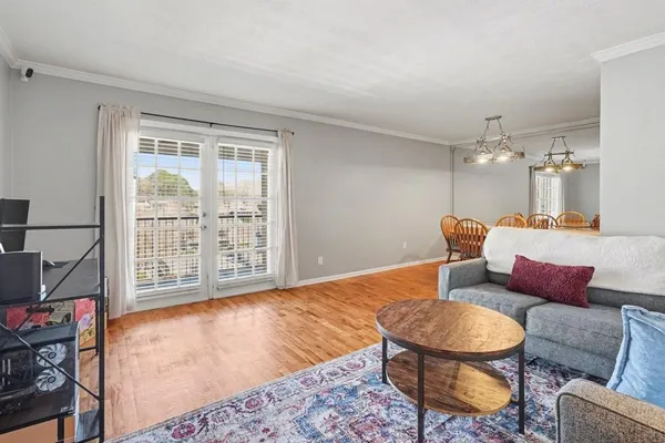 a living room with furniture a rug and a floor to ceiling window