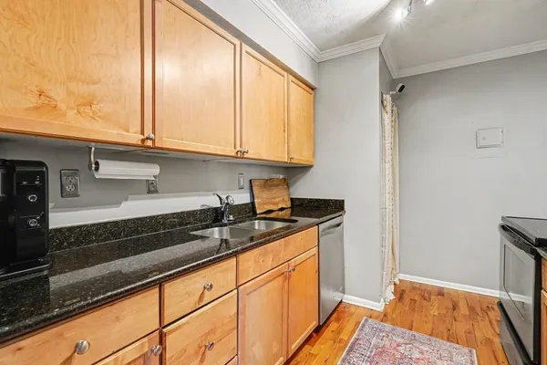 a kitchen with granite countertop a sink and a stove top oven