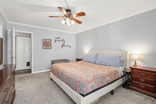 a bedroom with a bed chandelier and a window