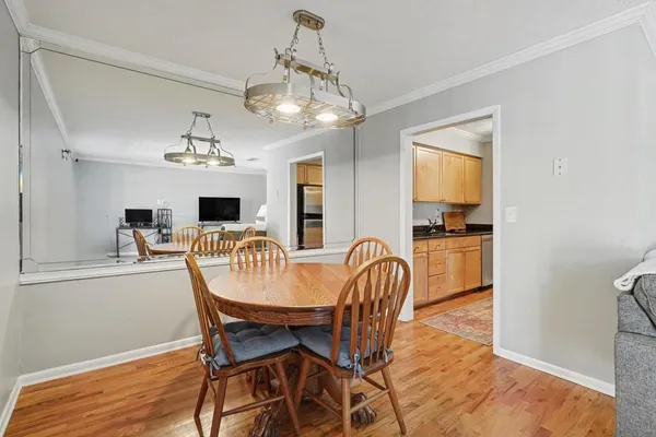 a view of a dining room with furniture a chandelier and wooden floor