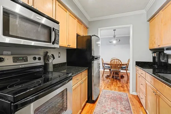 a kitchen with stainless steel appliances granite countertop a stove refrigerator and a microwave