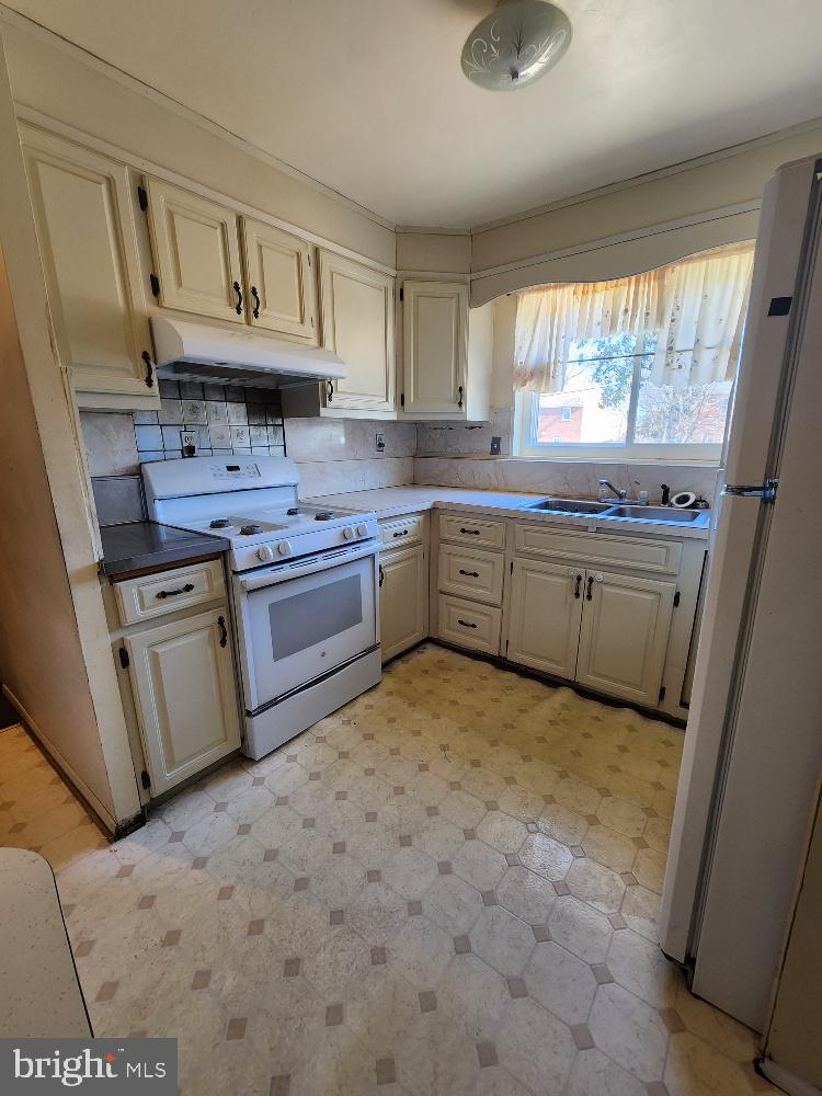 1108 Chaplin Street Southeast Washington, DC 20019 - Photo 17 of 35 a kitchen with stainless steel appliances granite countertop a sink stove and refrigerator