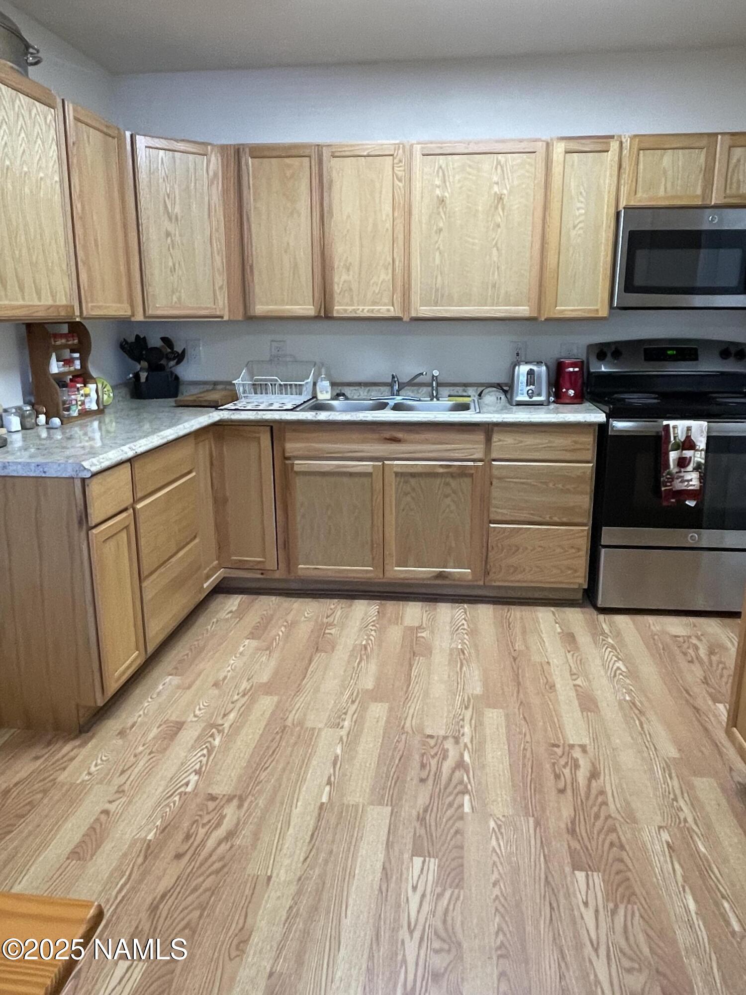 7681 East Robin Hood Road Williams, AZ 86046 - Photo 14 of 17 a kitchen with granite countertop a stove a sink and a microwave