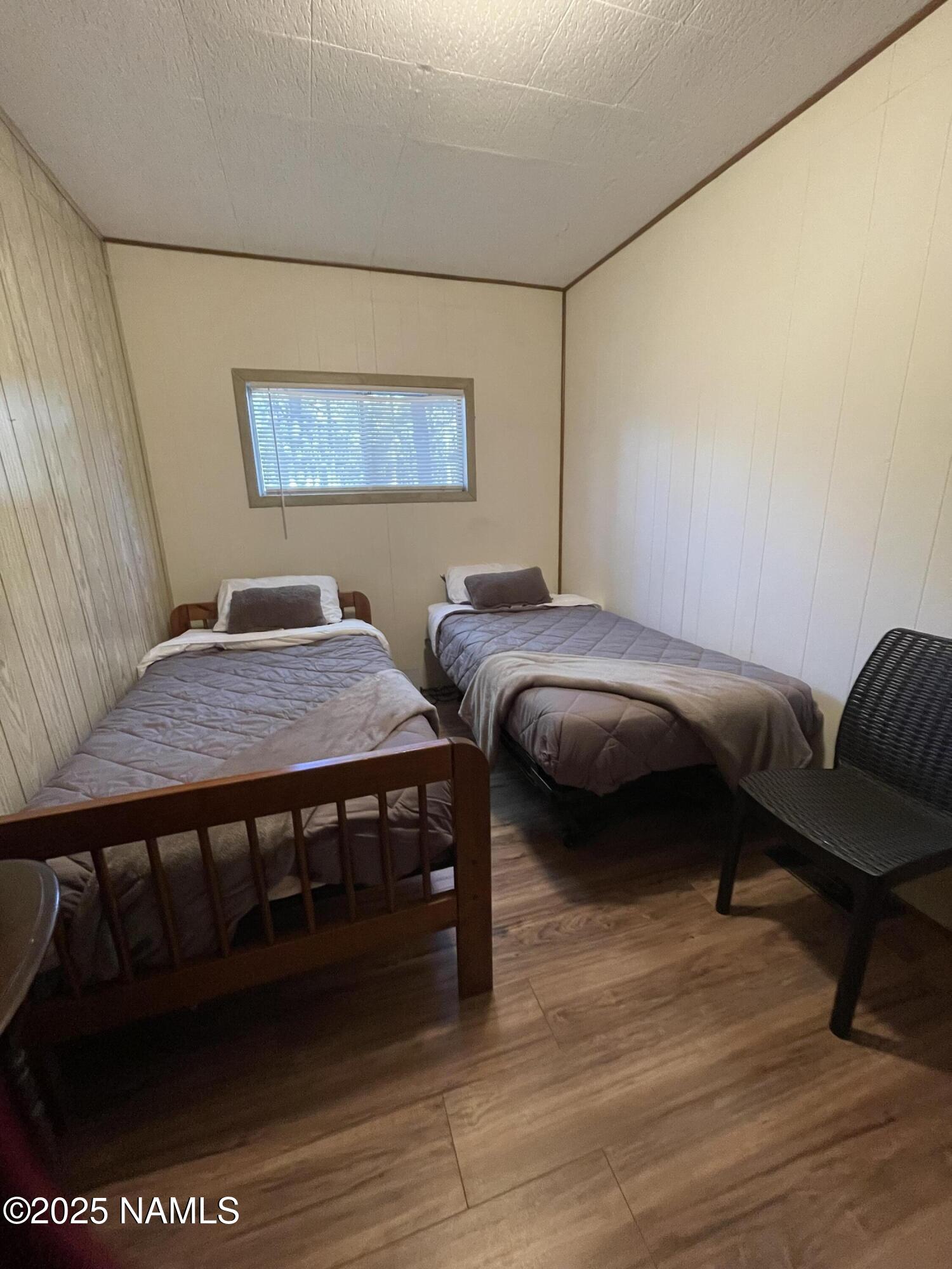 7681 East Robin Hood Road Williams, AZ 86046 - Photo 5 of 17 a bedroom with a bed and a chair