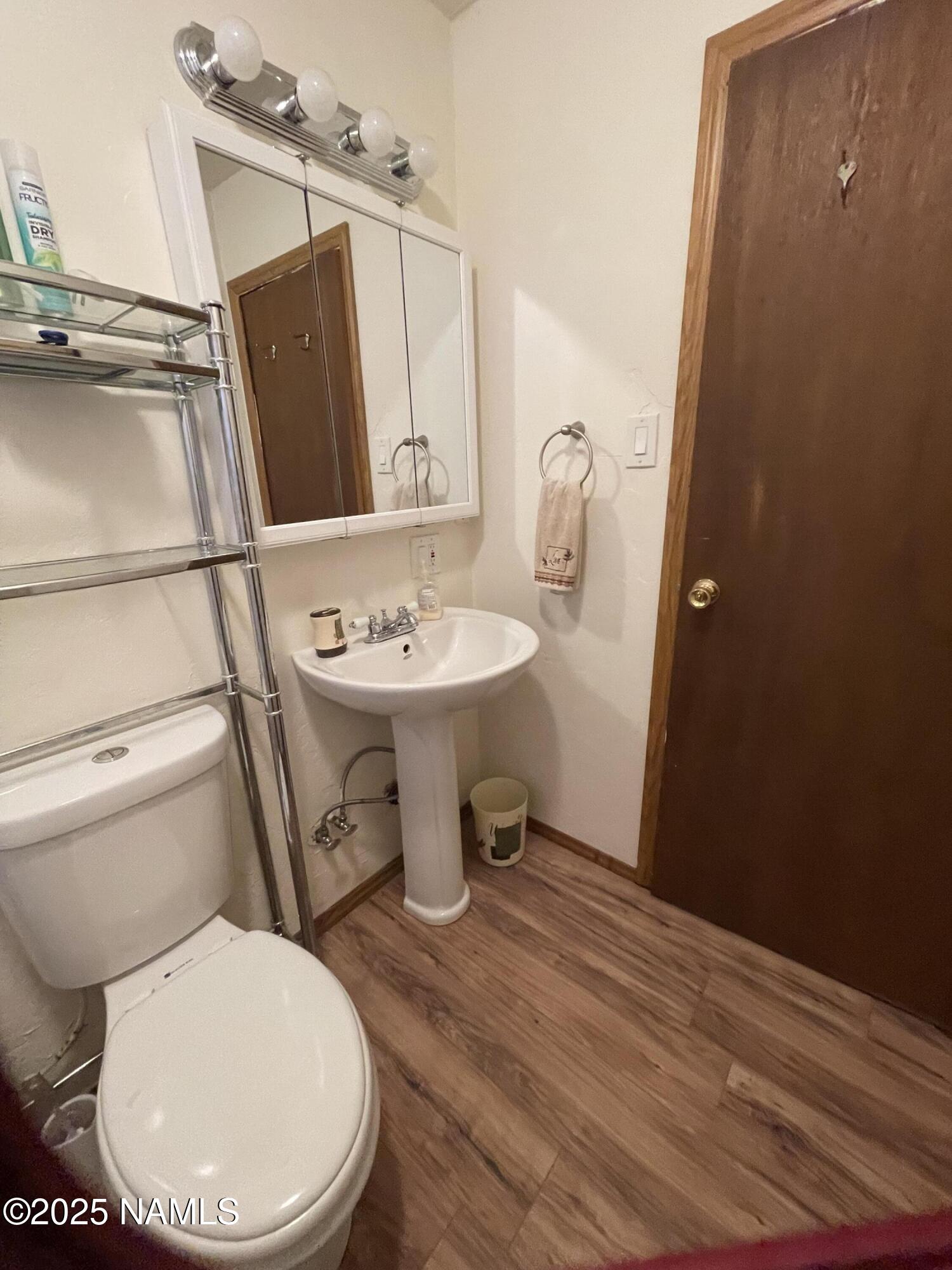 7681 East Robin Hood Road Williams, AZ 86046 - Photo 7 of 17 a bathroom with a toilet a sink and mirror