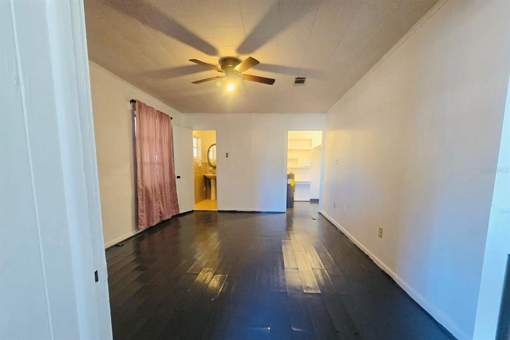 8010 Southeast Us Highway, Unit 5B Hawthorne, FL 32640 - Photo 5 of 7 a view of an empty room with wooden floor and a ceiling fan