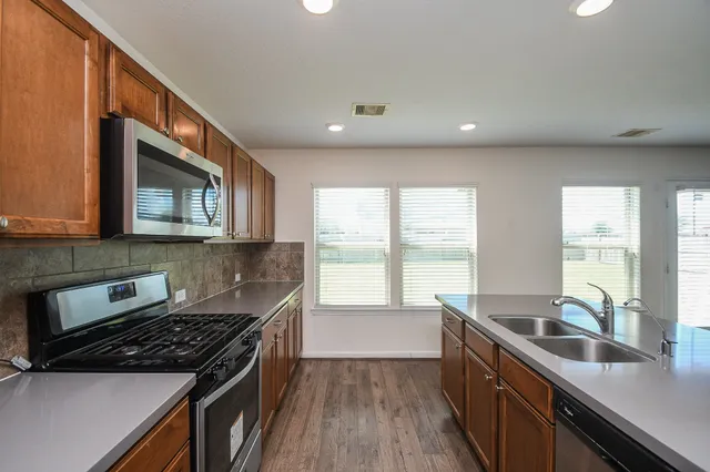 a kitchen with stainless steel appliances granite countertop a sink stove and cabinets