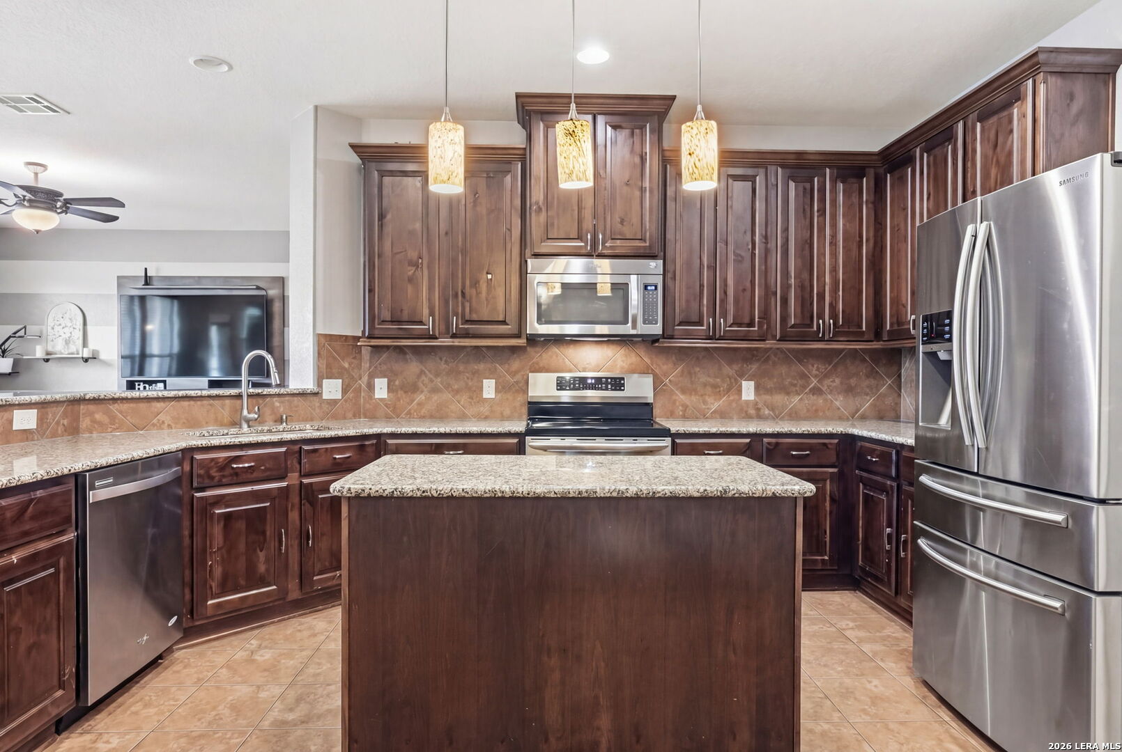 516 Brook Shadow Cibolo, TX 78108 - Photo 14 of 39 a kitchen with kitchen island granite countertop a sink stove and refrigerator