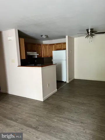 a view of kitchen with stainless steel appliances wooden floor and chair