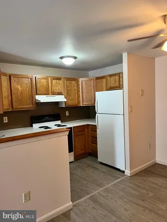 a kitchen with a refrigerator a stove top oven cabinets and a refrigerator