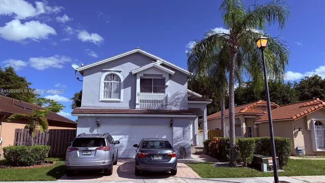 a front view of a house with a garden and plants