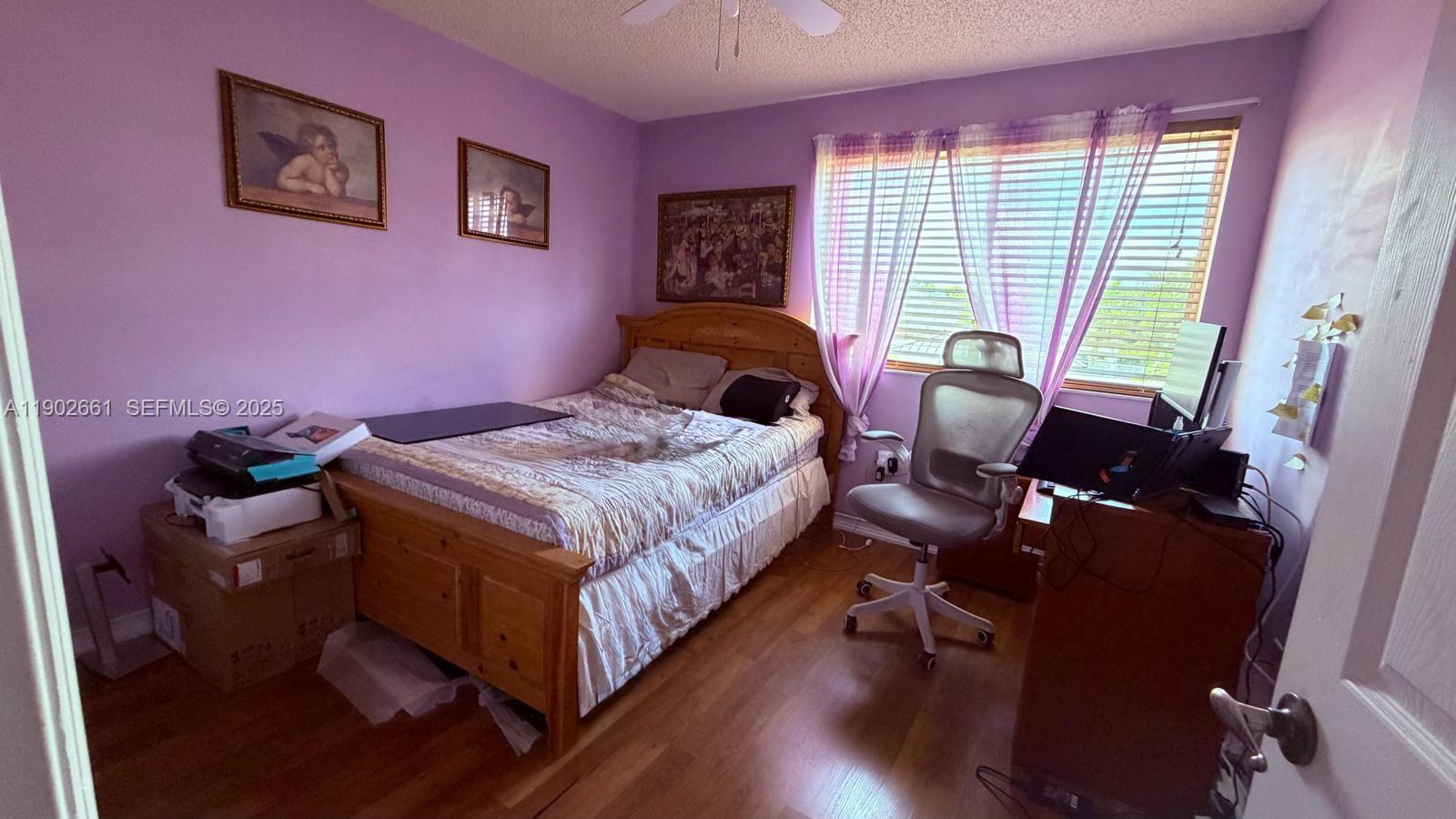 14713 Southwest 155th Place Miami, FL 33196 - Photo 15 of 23 a bedroom with a bed and wooden floor