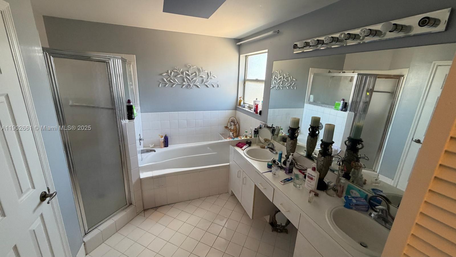 14713 Southwest 155th Place Miami, FL 33196 - Photo 17 of 23 a bathroom with a tub sink and mirror