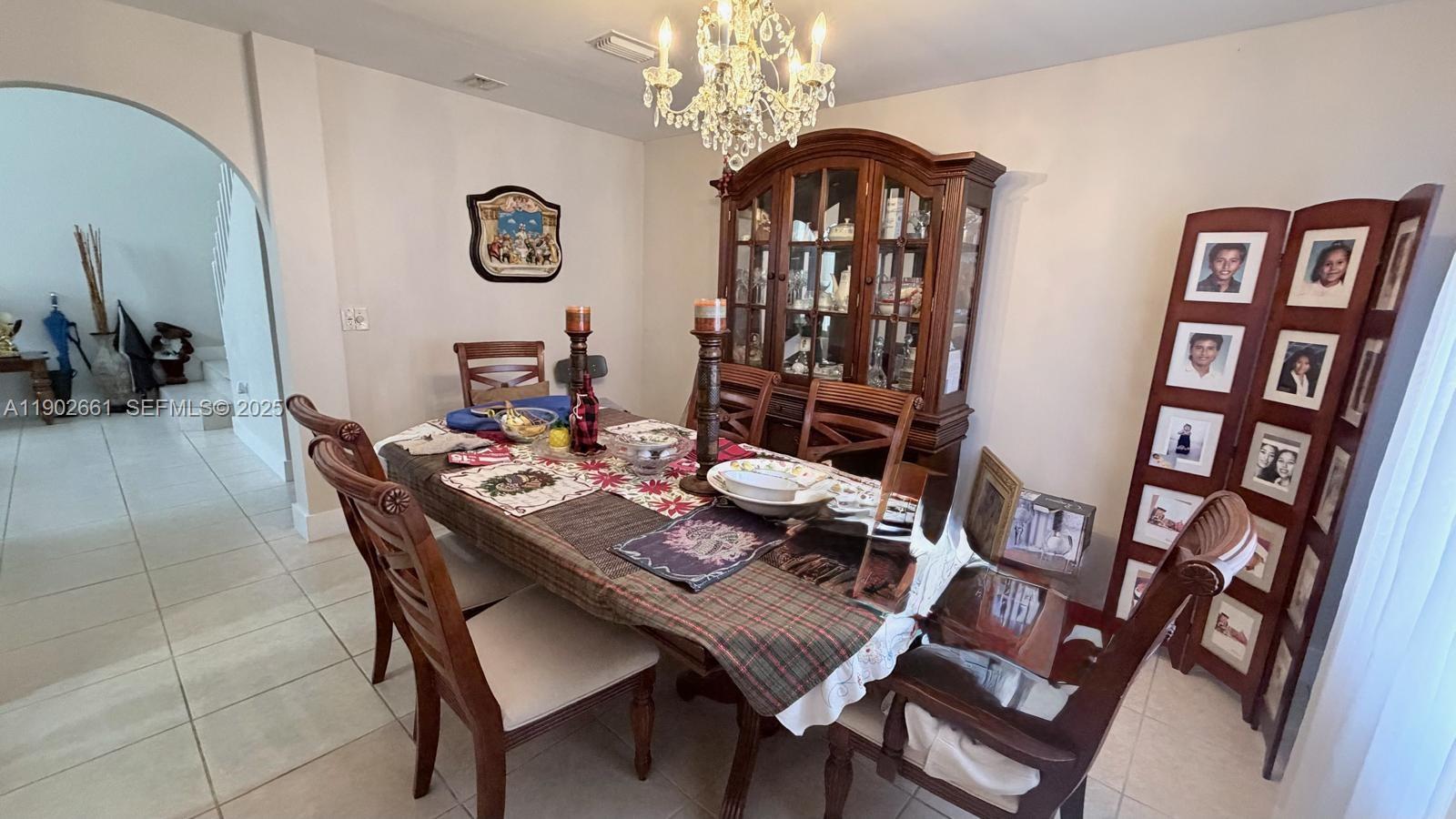 14713 Southwest 155th Place Miami, FL 33196 - Photo 4 of 23 a view of a dining room with furniture and a chandelier