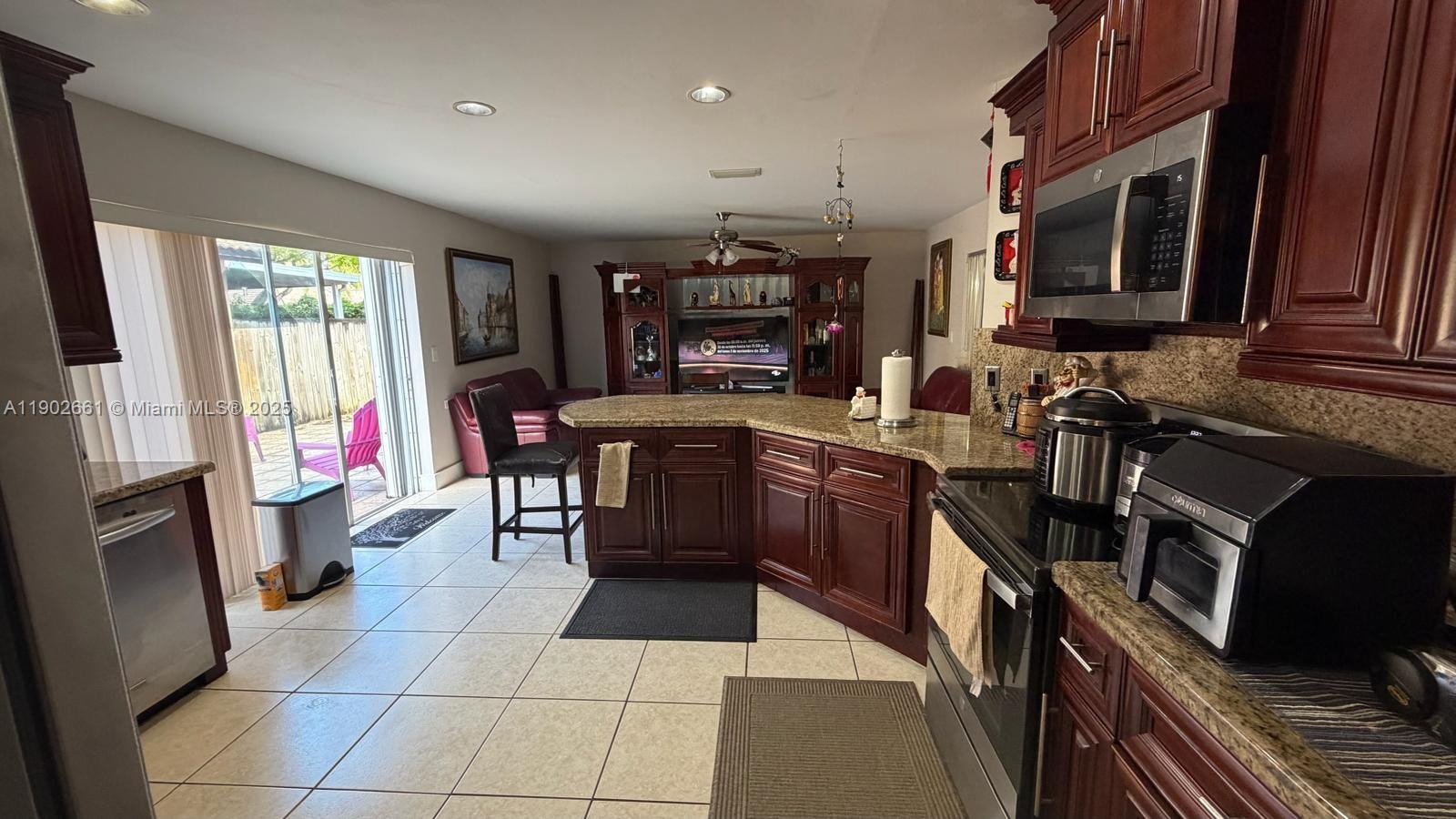 14713 Southwest 155th Place Miami, FL 33196 - Photo 5 of 23 a kitchen with a sink a stove and a microwave