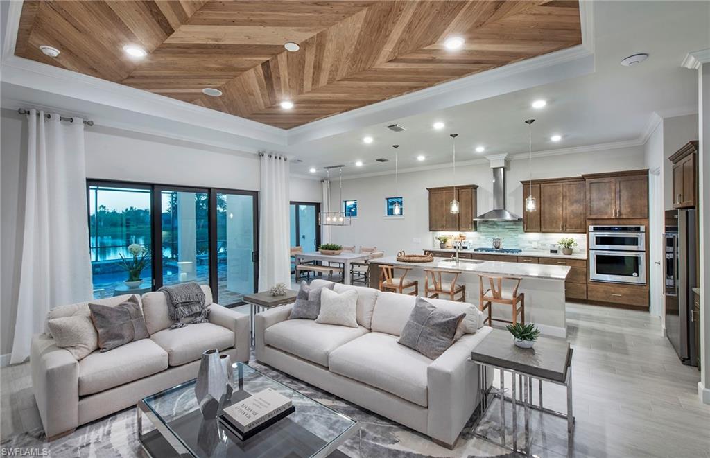 2126 Yellowfin Circle Naples, FL 34114 - Photo 12 of 29 a living room with furniture wooden floor kitchen view and a chandelier