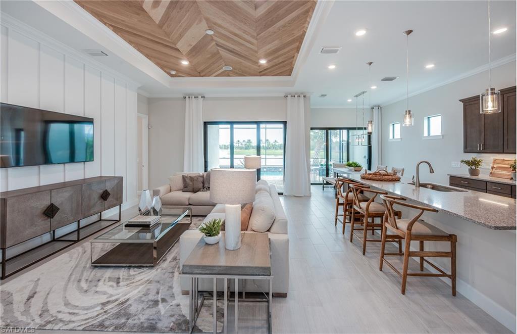2126 Yellowfin Circle Naples, FL 34114 - Photo 13 of 29 a living room with furniture a flat screen tv and a large window