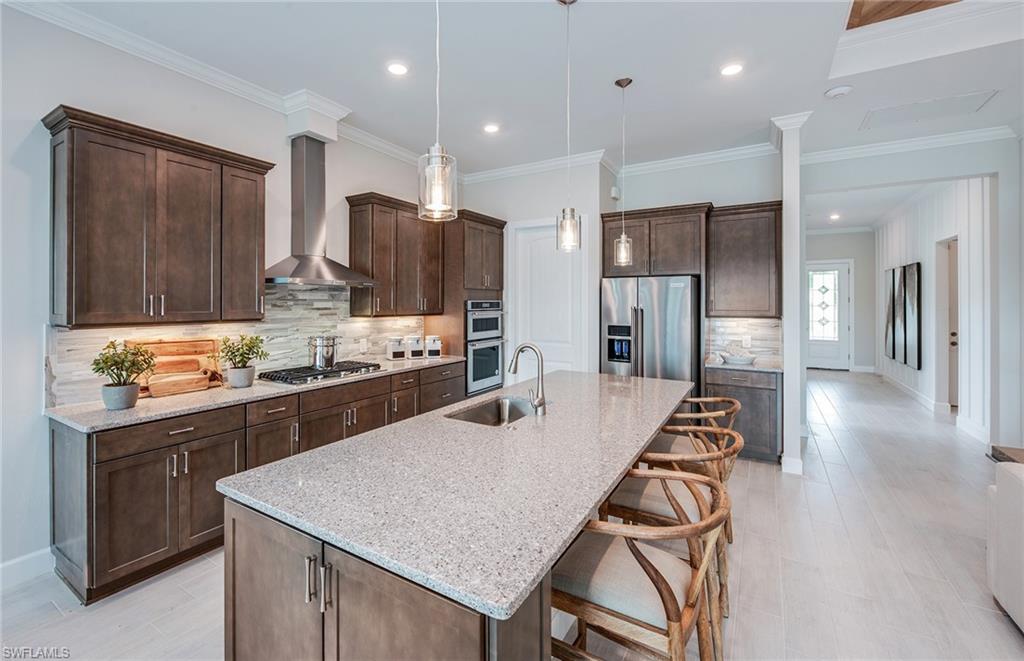 2126 Yellowfin Circle Naples, FL 34114 - Photo 14 of 29 a kitchen with stainless steel appliances granite countertop a kitchen island hardwood floor sink stove and granite counter top