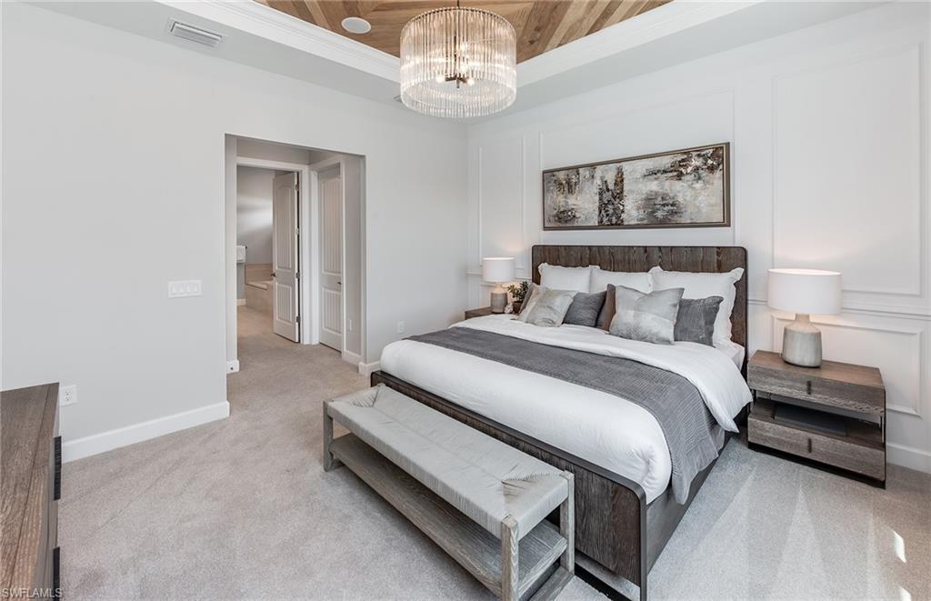 2126 Yellowfin Circle Naples, FL 34114 - Photo 17 of 29 a bedroom with a bed and a chandelier