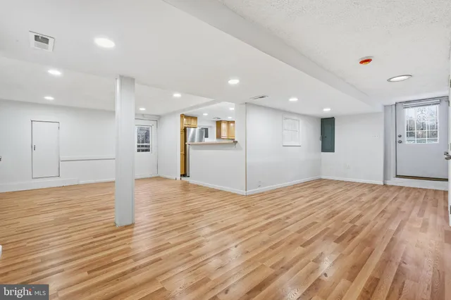 a view of empty room with wooden floor