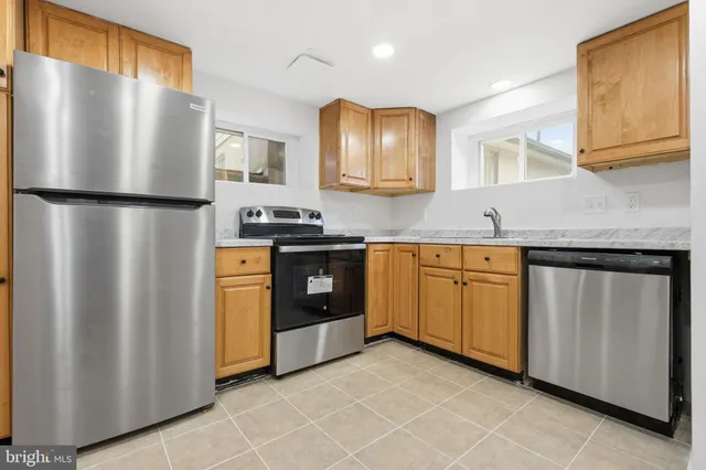 a kitchen with stainless steel appliances granite countertop a refrigerator a sink a stove and dishwasher