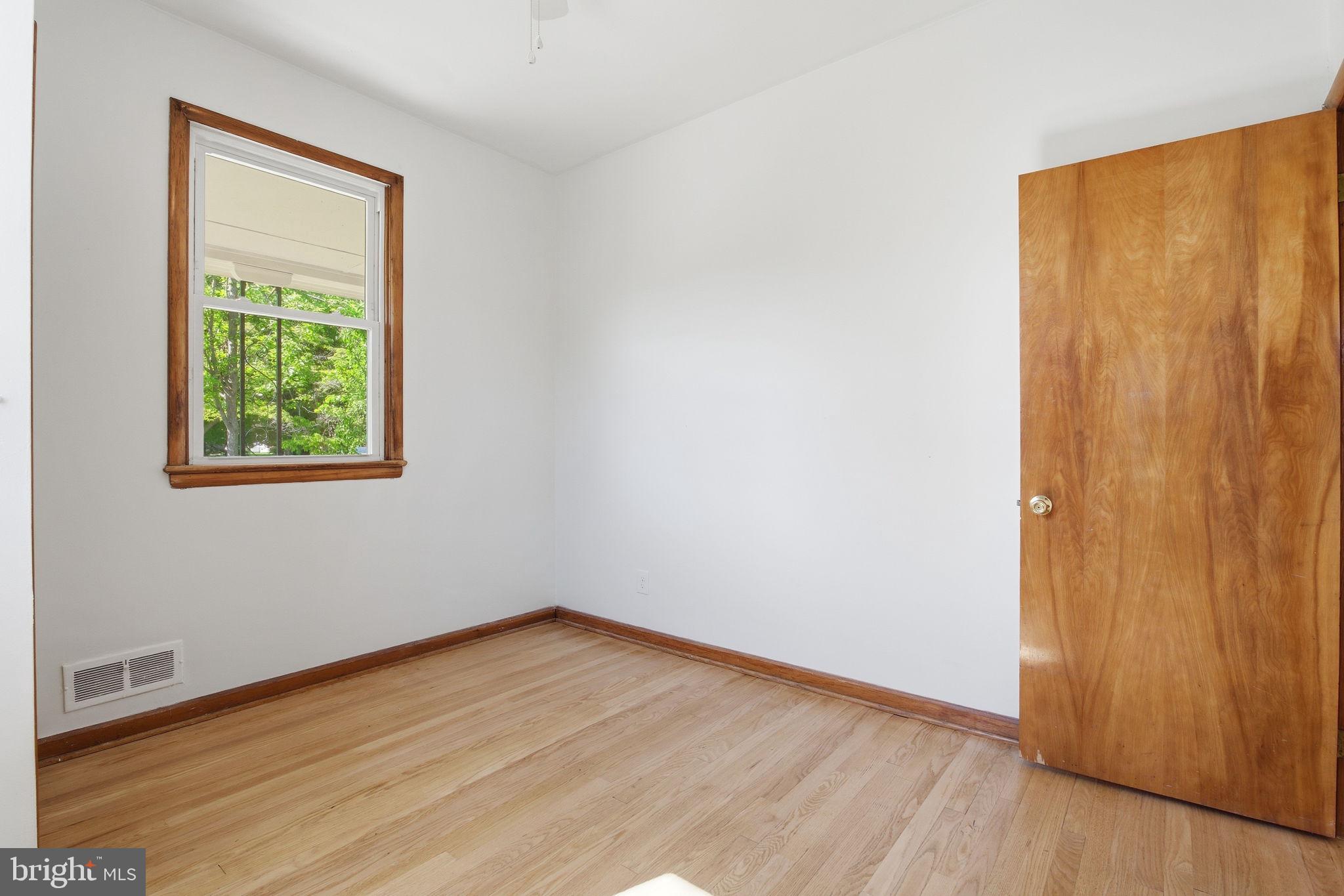 2301 Bayside Drive Baltimore, MD 21221 - Photo 21 of 35 an empty room with wooden floor and windows