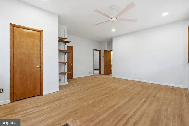 an empty room with closet and a ceiling fan