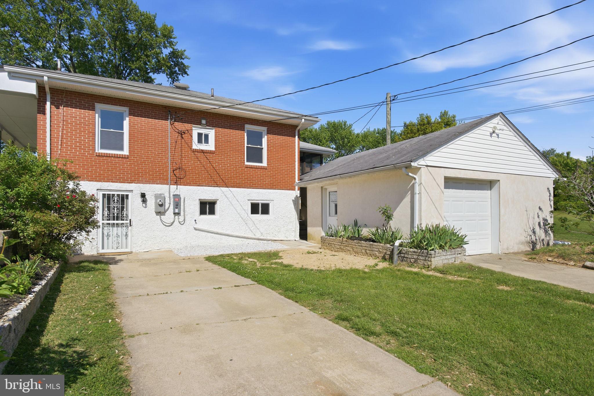 2301 Bayside Drive Baltimore, MD 21221 - Photo 3 of 35 a front view of a house with a yard and garage