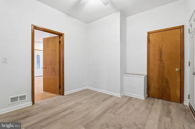 an empty room with wooden floor and closet