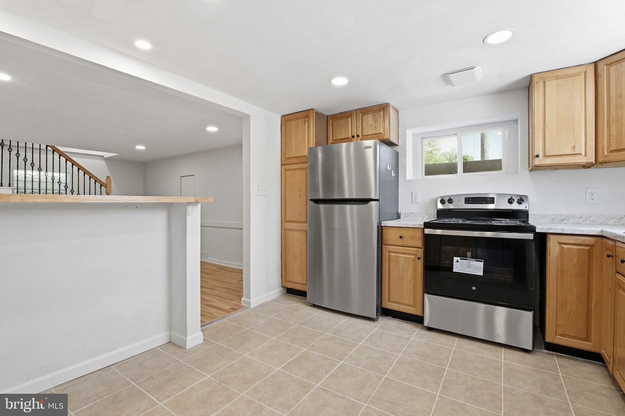 2301 Bayside Drive Baltimore, MD 21221 - Photo 10 of 35 a kitchen with a refrigerator a stove and a cabinets