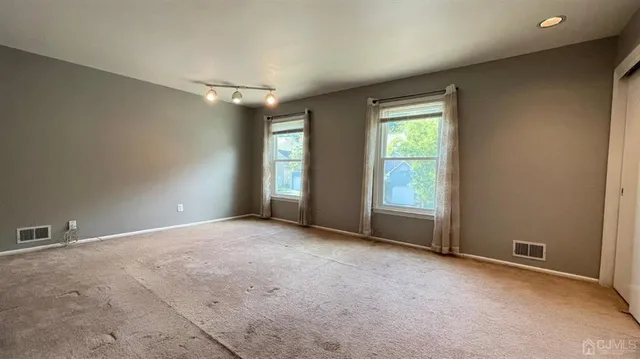 an empty room with windows and closet
