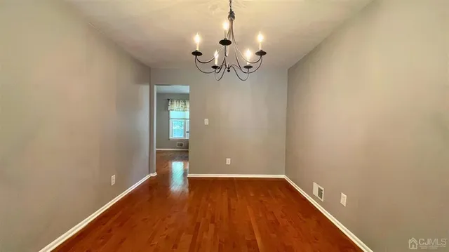 a view of a room with wooden floor and chandelier