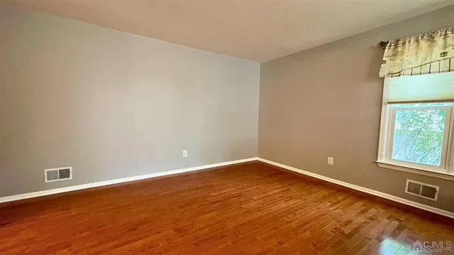 a view of a room with wooden floor and windows