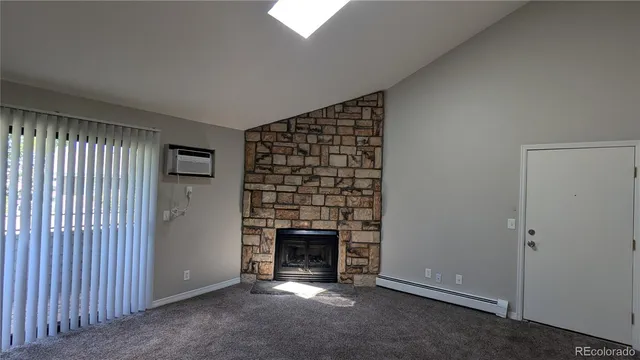 a view of an empty room with a fireplace and window