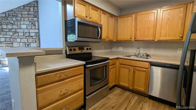 a kitchen with stainless steel appliances a stove microwave and sink