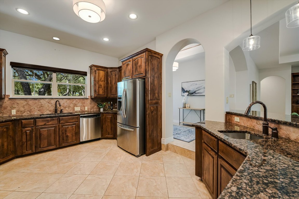 524 Highland Spring Lane Georgetown, TX 78633 - Photo 11 of 39 a kitchen with stainless steel appliances granite countertop a refrigerator a stove a sink and a microwave