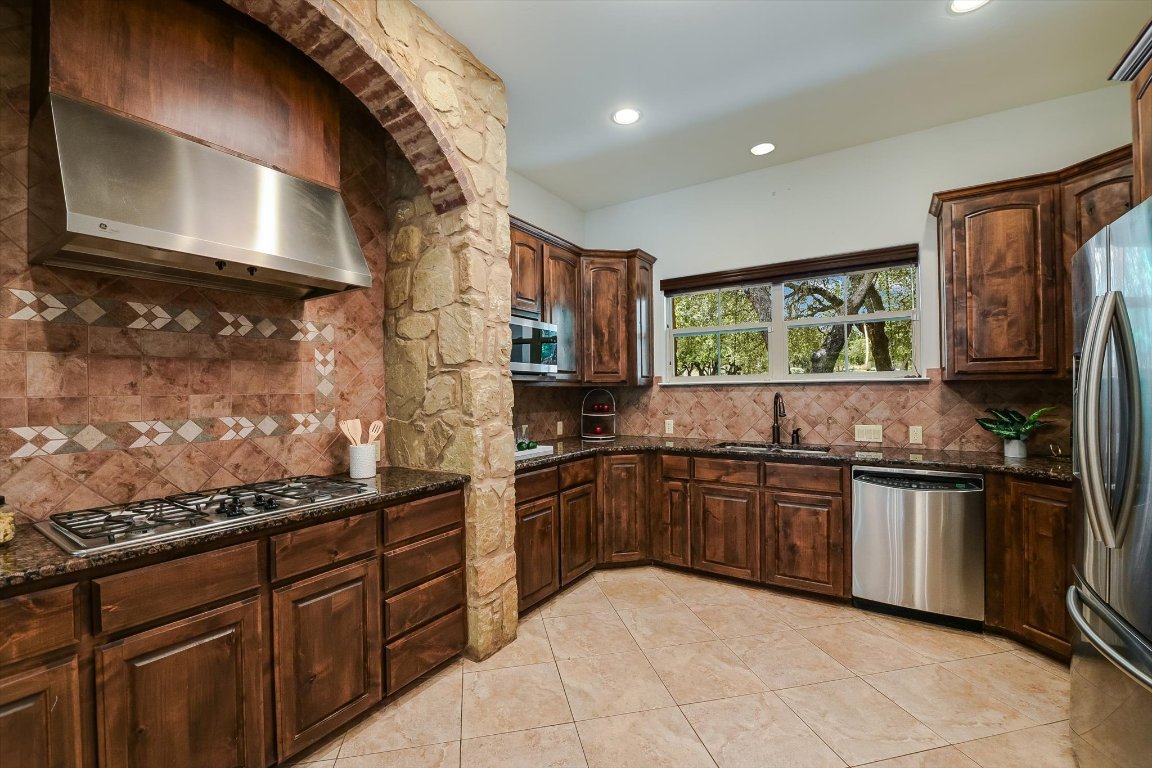 524 Highland Spring Lane Georgetown, TX 78633 - Photo 10 of 39 a kitchen with stainless steel appliances granite countertop a stove sink and cabinets