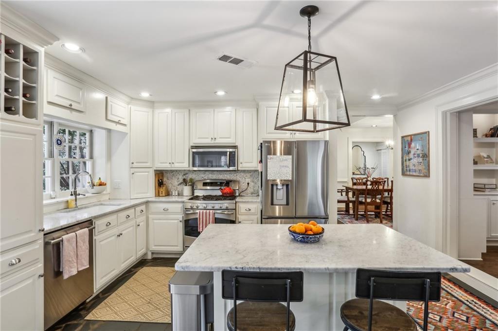 2415 Oldfield Road Northwest Atlanta, GA 30327 - Photo 12 of 27 a kitchen with stainless steel appliances granite countertop a stove refrigerator and cabinets