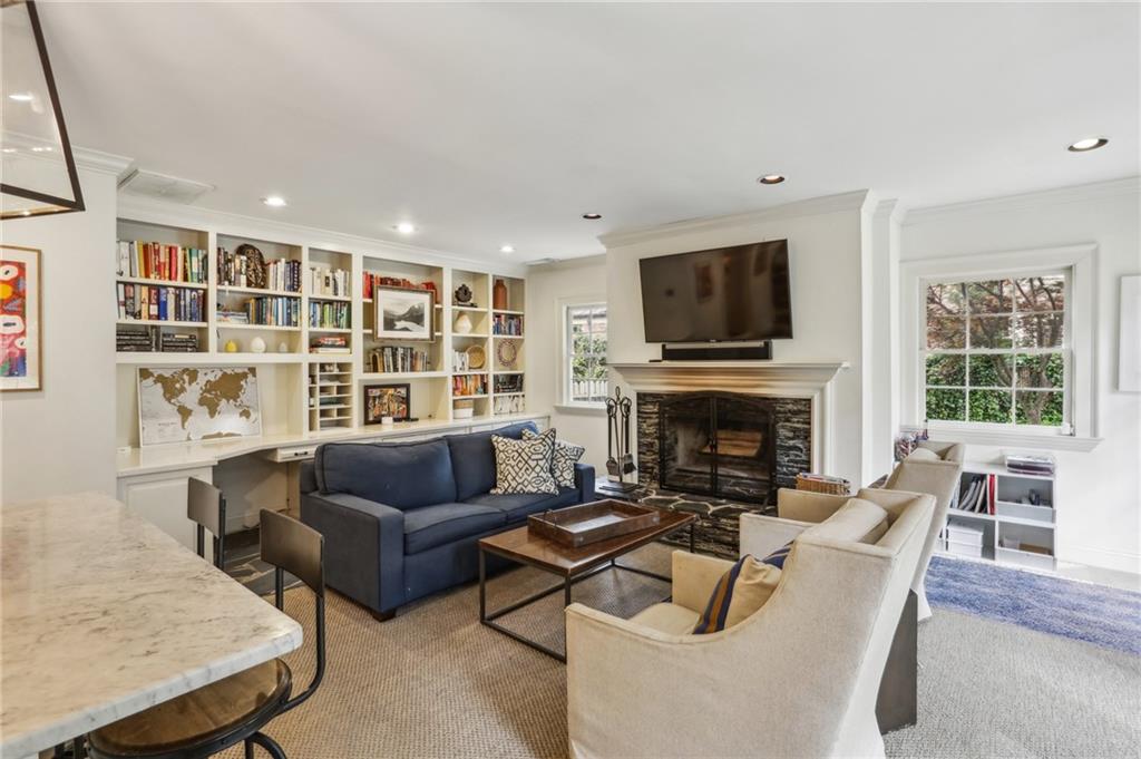 2415 Oldfield Road Northwest Atlanta, GA 30327 - Photo 14 of 27 a living room with furniture a flat screen tv and a fireplace
