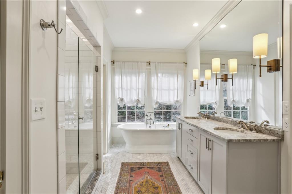 2415 Oldfield Road Northwest Atlanta, GA 30327 - Photo 20 of 27 a bathroom with a double vanity sink and mirror with bathtub