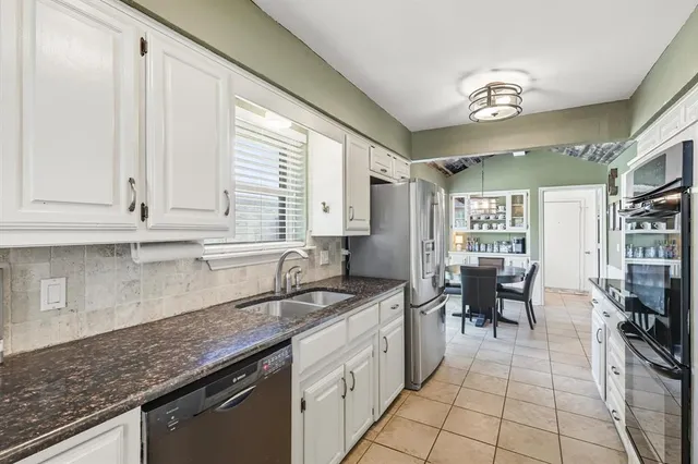 a kitchen with stainless steel appliances granite countertop a refrigerator and a stove